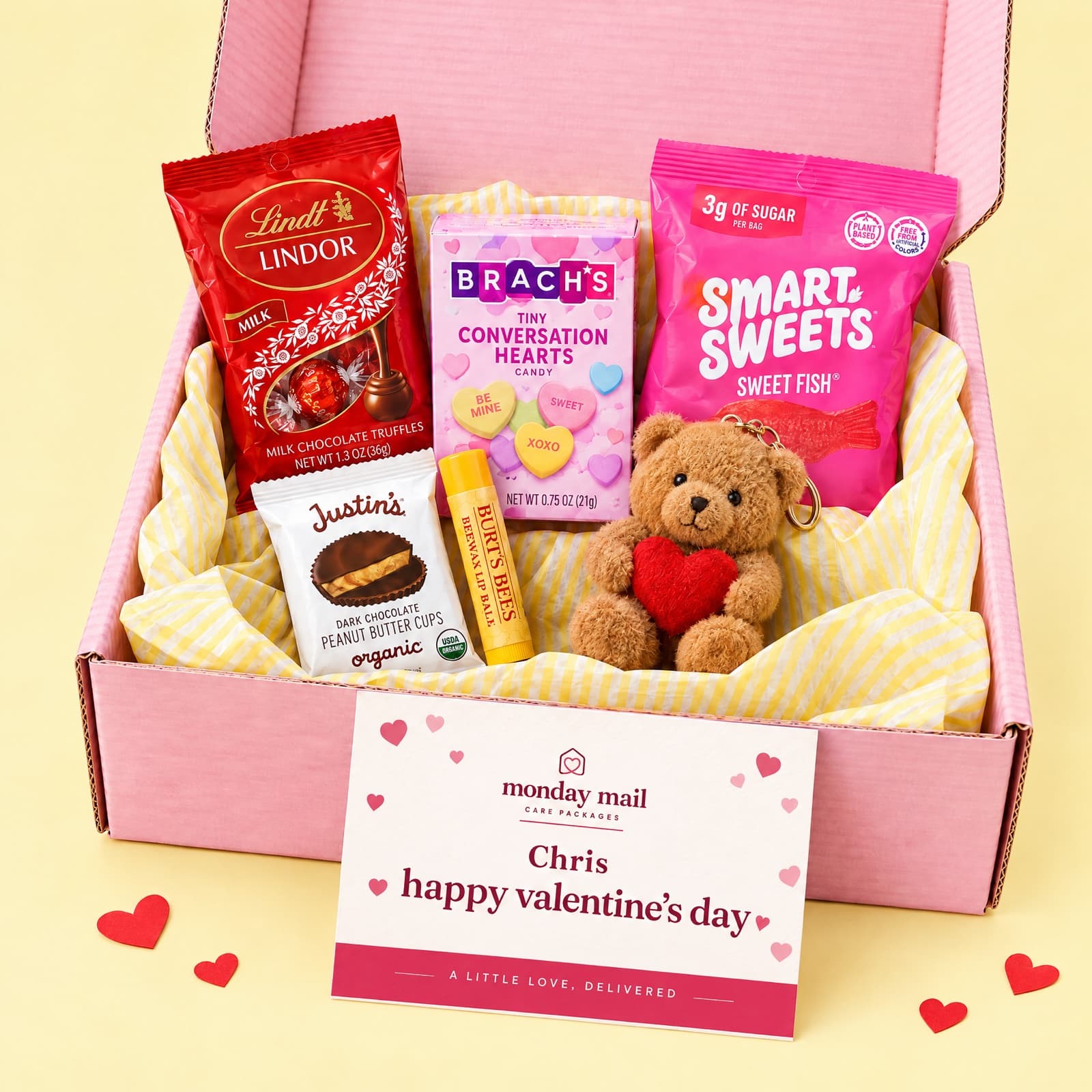 The pink Valentine's box with Lindt truffles, conversation hearts, SmartSweets, peanut butter cups, lip balm and a heart bear